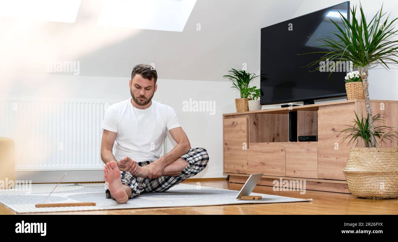 Esercizi di yoga per imparare l'uomo principiante per lo stretching. Foto Stock