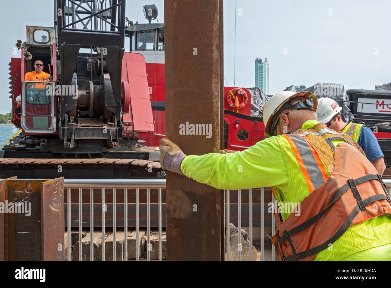 Detroit, Michigan - i lavoratori riparano il muro di mare lungo il lungofiume di Detroit usando un driver della pila montato su una chiatta sul fiume di Detroit. Foto Stock