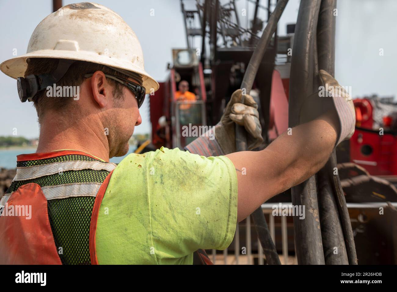 Detroit, Michigan - i lavoratori riparano il muro di mare lungo il lungofiume di Detroit usando un driver della pila montato su una chiatta sul fiume di Detroit. Foto Stock
