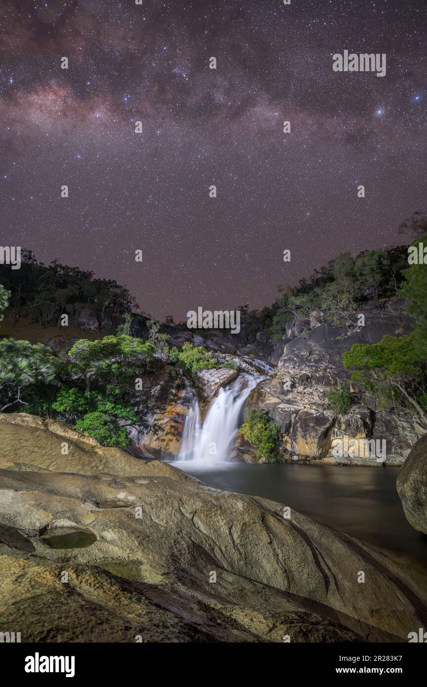 Una splendida immagine notturna delle Emerald Creek Falls attraversate dal nucleo di milkyway in una notte limpida a Mareba, Queensland, Australia. Foto Stock