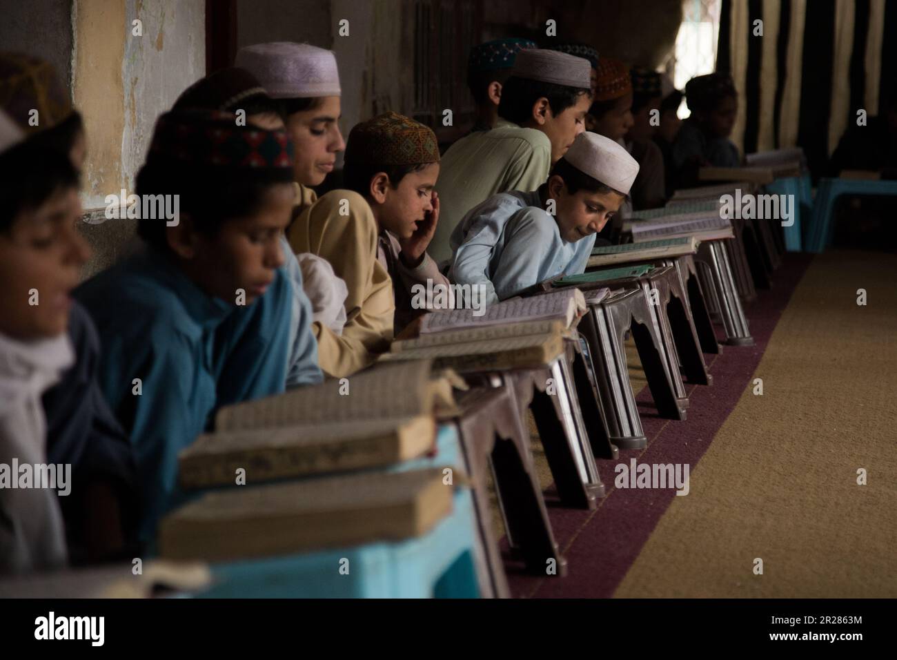 Preservare la conoscenza e la tradizione: Bambini impegnati nell'apprendimento in una scuola tradizionale in KPK, Pakistan Foto Stock
