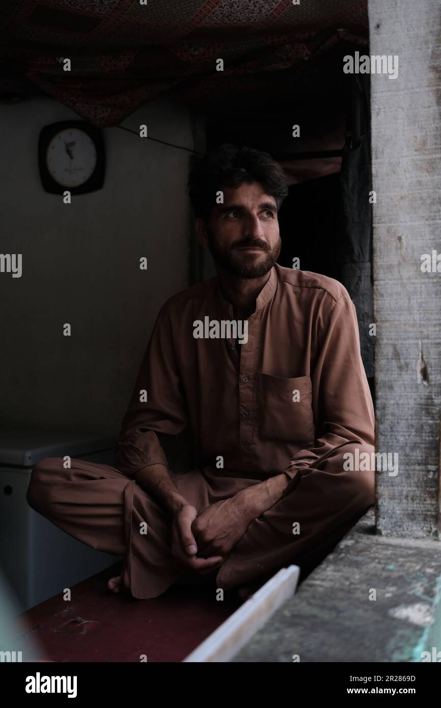 Catturare l'essenza: Un ritratto di un uomo in un kameez shalwar marrone, che rappresenta il ricco patrimonio culturale di un remoto villaggio in Pakistan Foto Stock