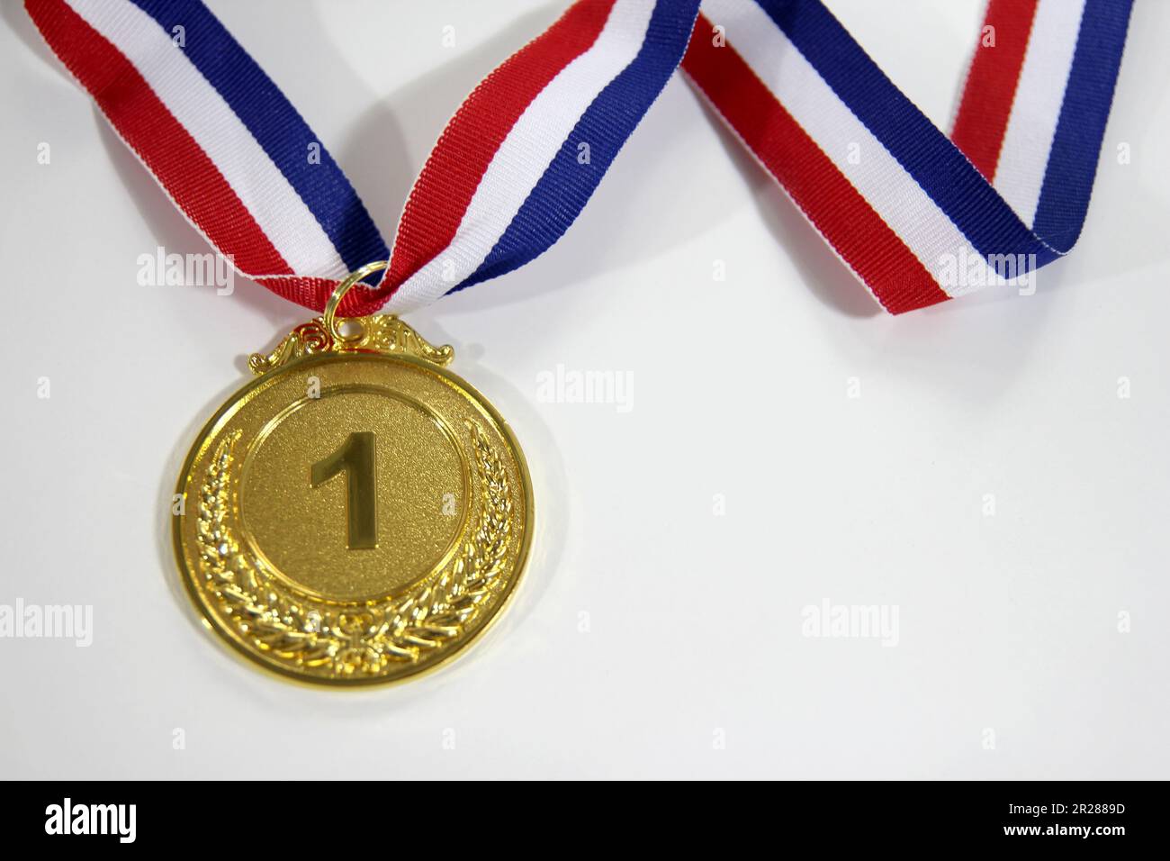 Medaglia d'oro 1° posto con un nastro su sfondo grigio chiaro, il concetto di vittoria o di successo Foto Stock