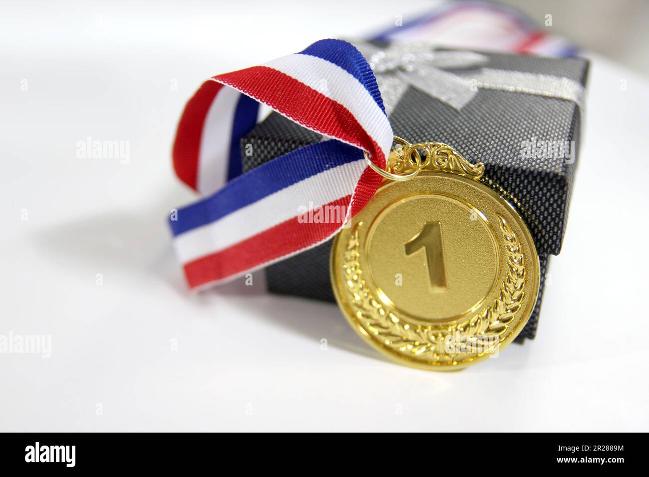 Medaglia d'oro 1° posto con un nastro su sfondo grigio chiaro, il concetto di vittoria o di successo Foto Stock