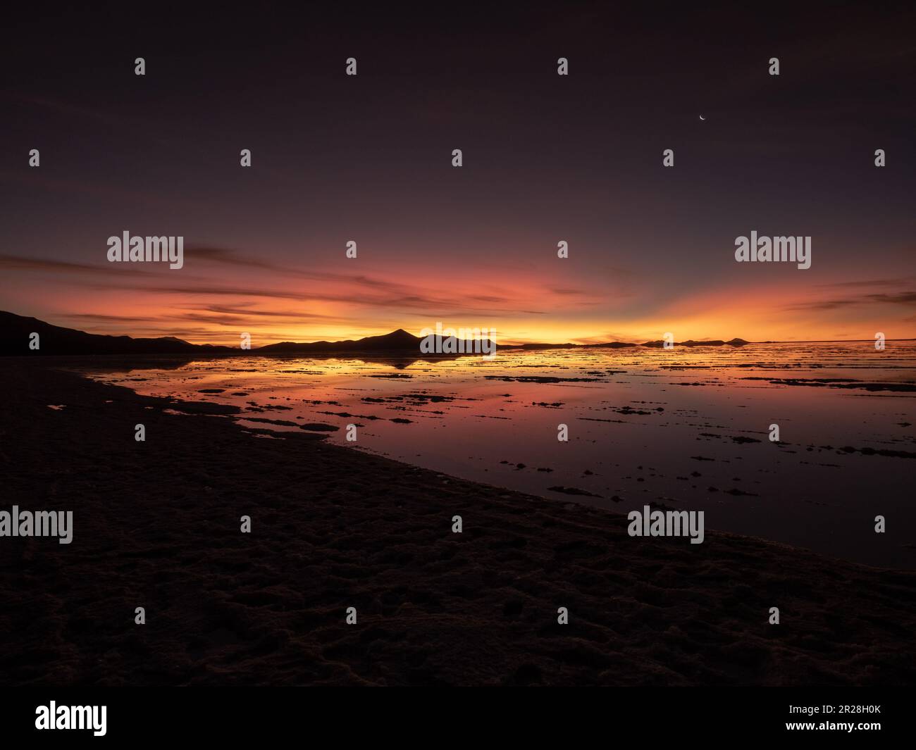 Immergiti nell'affascinante bellezza del tramonto sul Salar de Uyuni in Bolivia. Ammira gli incantevoli colori che dipingi le vaste distese di sale. Foto Stock