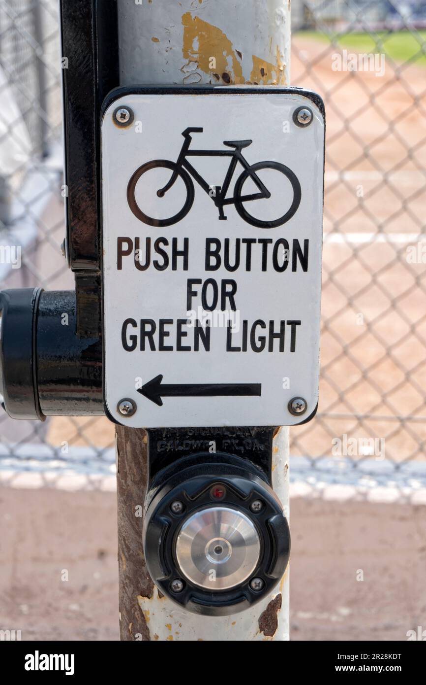 Pulsante bici per il cartello verde sul palo arrugginito. Foto Stock