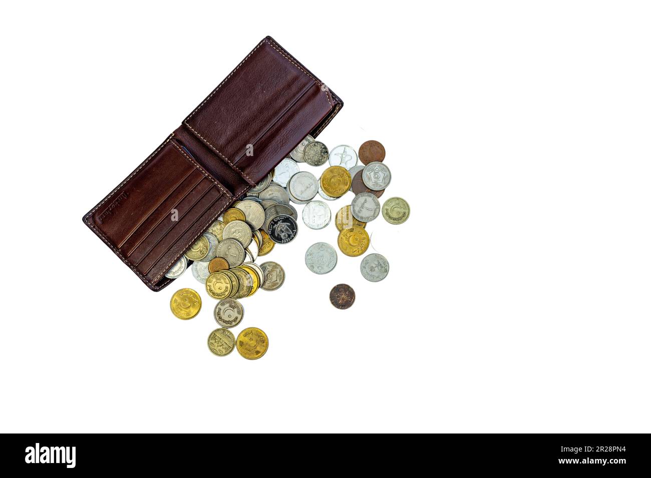 Un portafoglio in pelle marrone con monete che si stendono da esso su un isolato sfondo bianco vista dall'alto. messa a fuoco selettiva Foto Stock