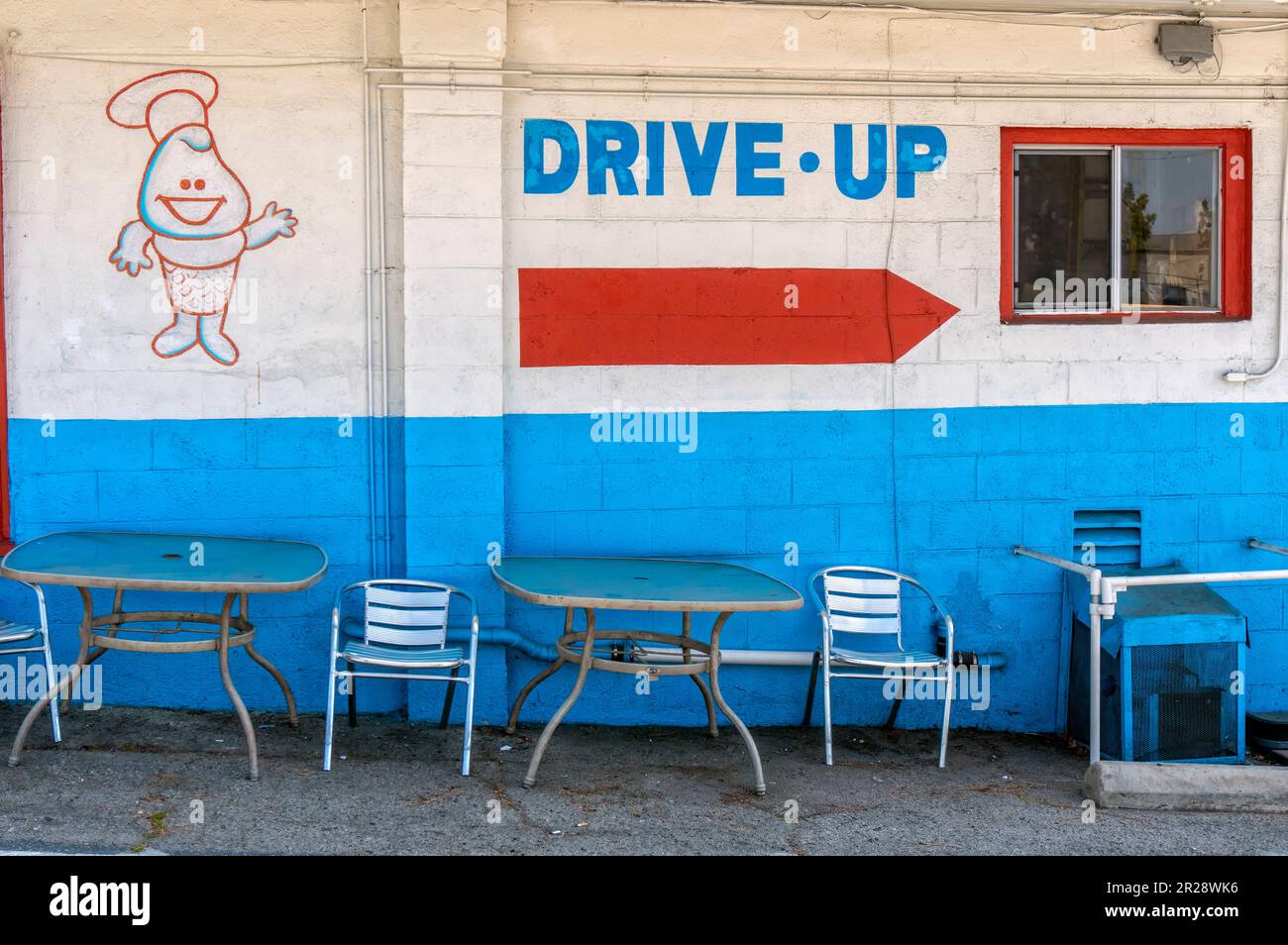 Un cartello dipinto sul muro che indica la strada per il drive through Foto Stock