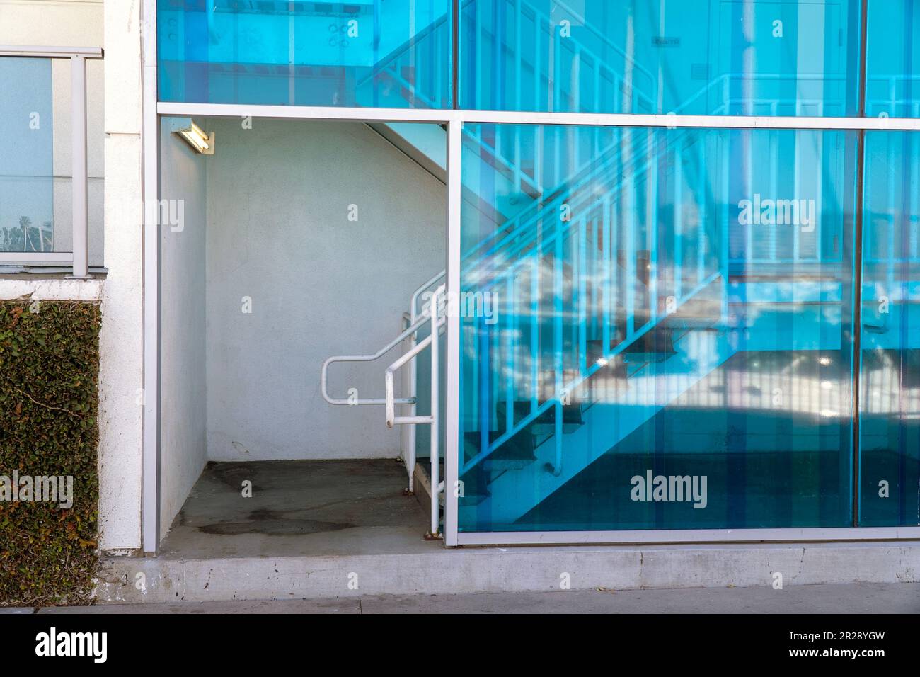 Ingresso di un edificio con scalinata e grandi finestre di colore blu. Foto Stock
