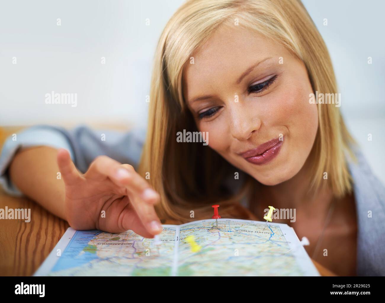 Agenzia di viaggi, mappa pin e volto di una donna felice, consulente o dipendente che pianifica la località di vacanza. Agente turistico, servizio di viaggio e sorriso per le persone Foto Stock