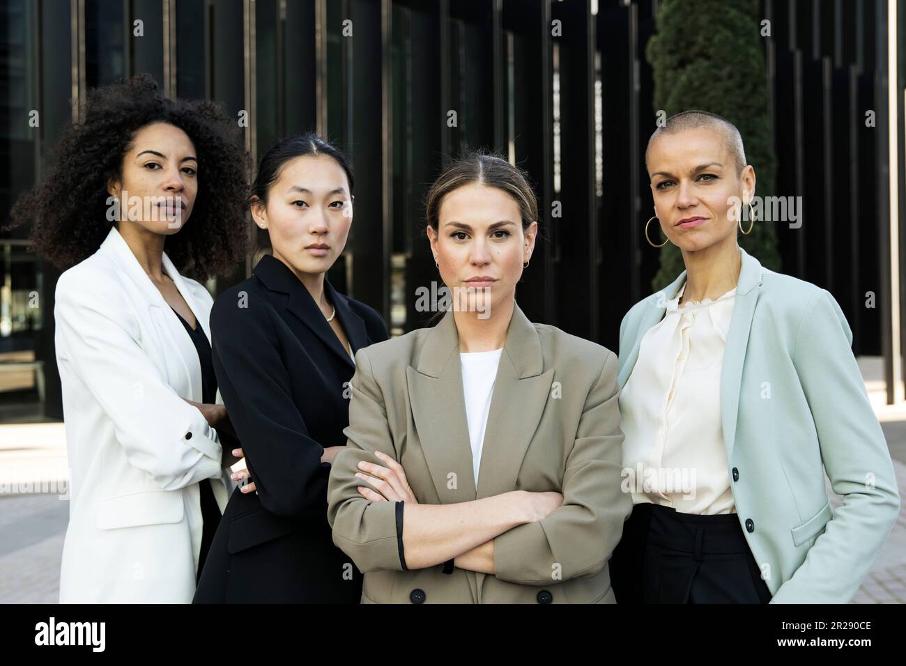 Gruppo di donne d'affari sicure e ambiziose che guardano la telecamera all'esterno. Squadra di giovani donne di successo determinate esecutive e fissando la macchina fotografica Foto Stock