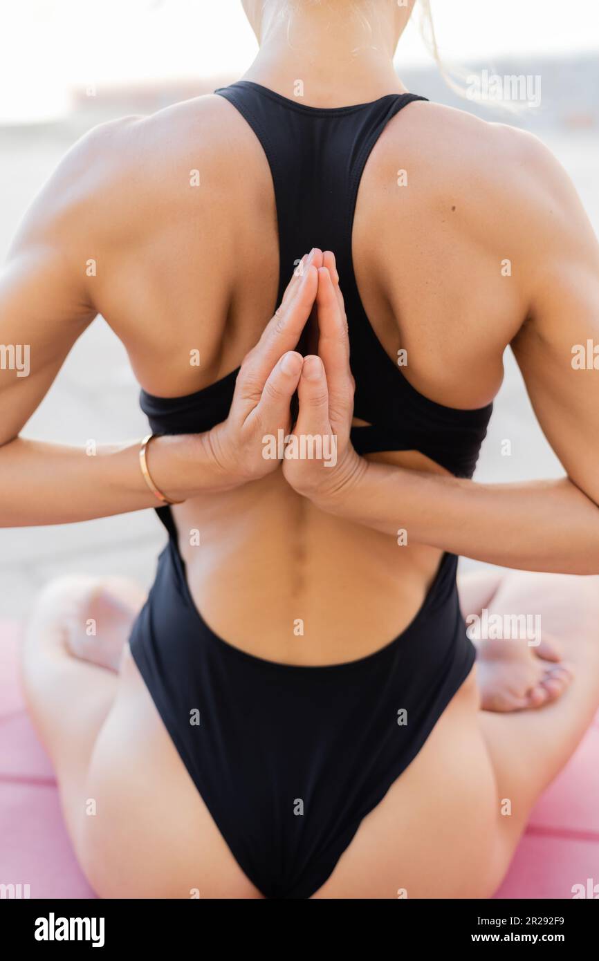 Vista posteriore della donna meditating in yoga asana outdoor Foto Stock