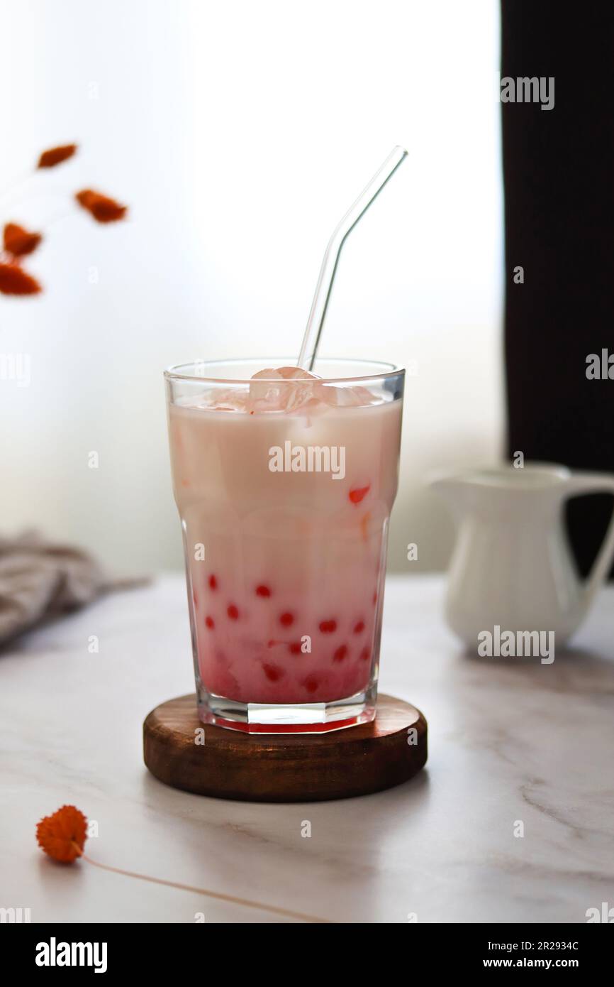 Homa ha fatto il tè freddo della bolla del latte con le perle di tapioca. Bevanda con tè al latte di fragola e palline di tapioca. Bevanda lattea con bolle di tapioka e ghiaccio Foto Stock