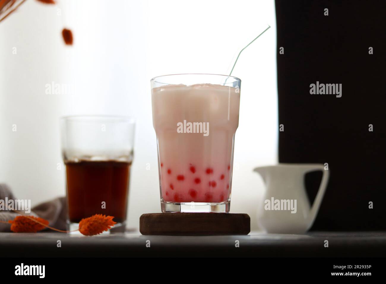 Tè fatto in casa con bolle di latte e perle di tapioca. Bevanda ghiacciata con tè al latte di fragola e palline di tapioca. Bevanda lattea con bolle di tapioka e ghiaccio Foto Stock