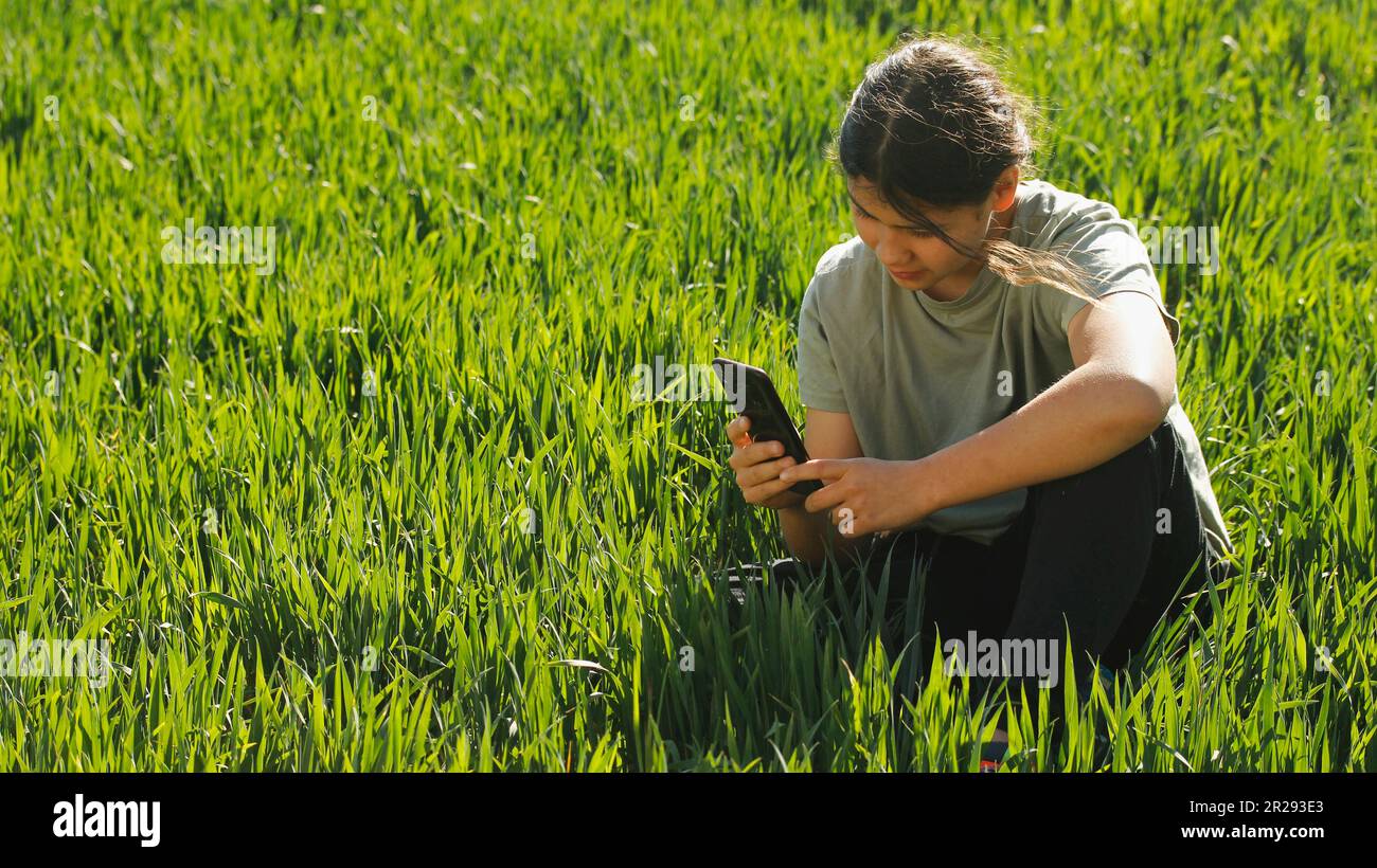 Ragazza su un prato con un cellulare. Foto Stock