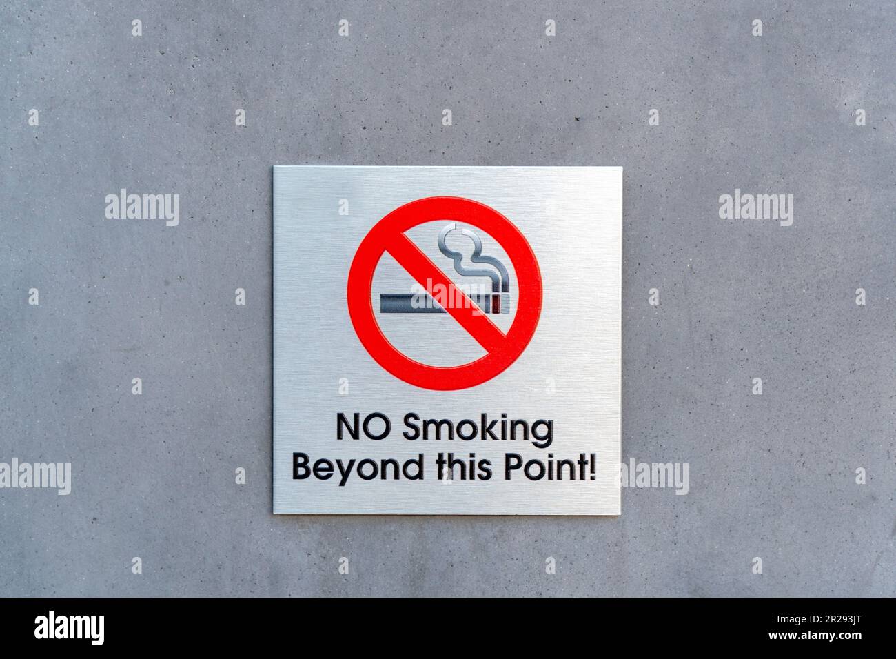 Non fumare oltre questa targhetta di metallo punto su una parete Foto Stock