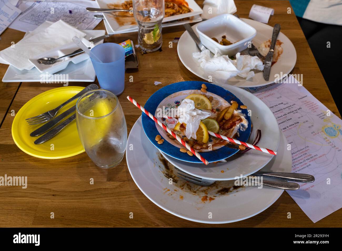 Un tavolo in un ristorante pieno di piatti sporchi dopo un pasto. Foto Stock