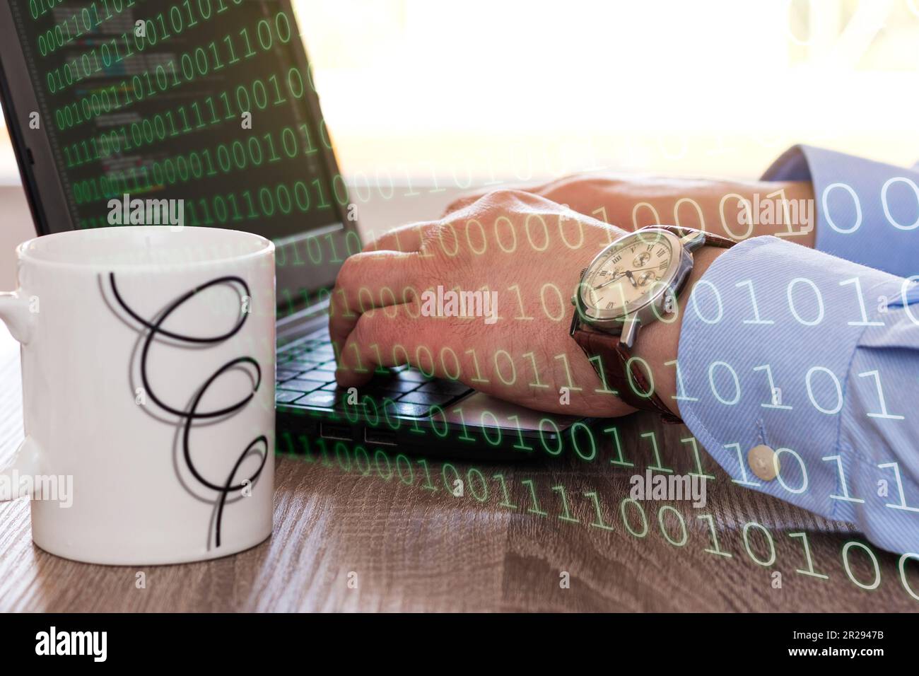 Ritagliare un lavoratore anonimo seduto al tavolo di legno con tazza bianca e digitando sulla tastiera del computer portatile mentre si lavora sul codice del programma Foto Stock