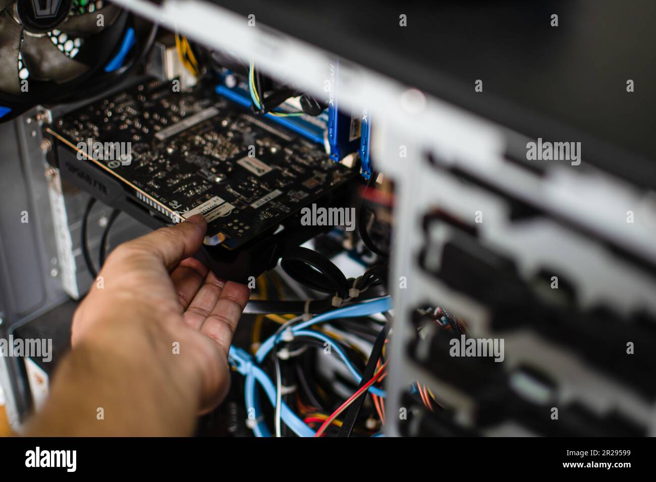 Una mano del tecnico tiene la scheda grafica per ripararla. La scheda VGA è danneggiata e il computer non funziona. La scheda video non visualizza un co personale Foto Stock