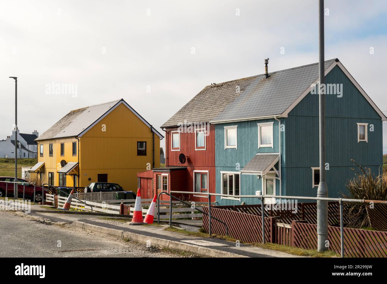 Rivestimenti colorati luminosi sulle case a Burravoe nel sud dell'isola di Yell, Shetland. Foto Stock