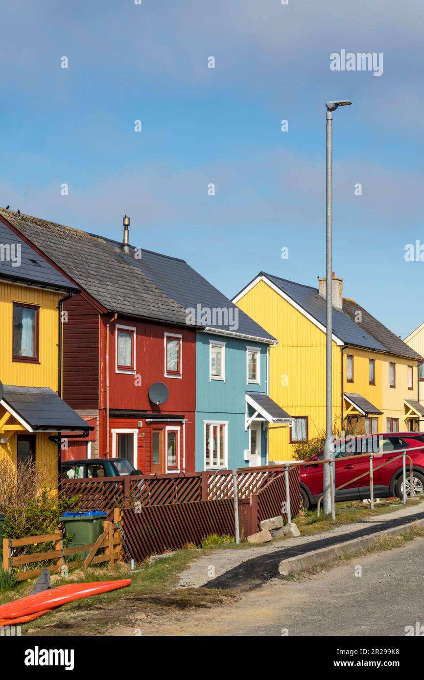 Rivestimenti colorati luminosi sulle case a Burravoe nel sud dell'isola di Yell, Shetland. Foto Stock