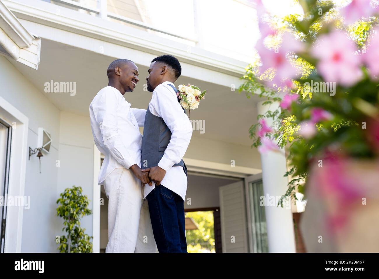 Basso angolo di vista di coppia afro-americana gay con faccia a faccia in piedi fuori casa Foto Stock