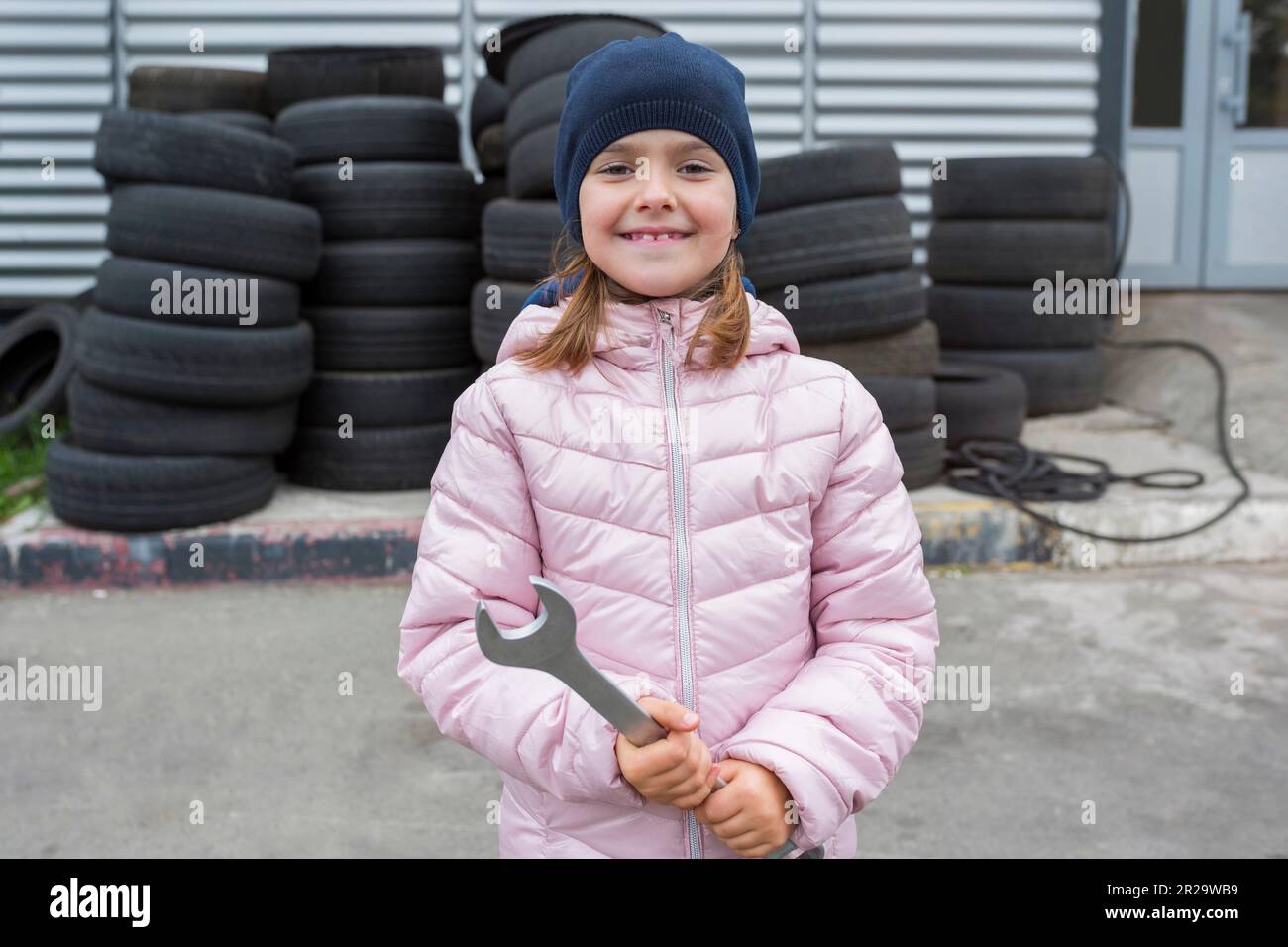 Ritratto di un bambino con una chiave in mano, sullo sfondo di un garage Foto Stock