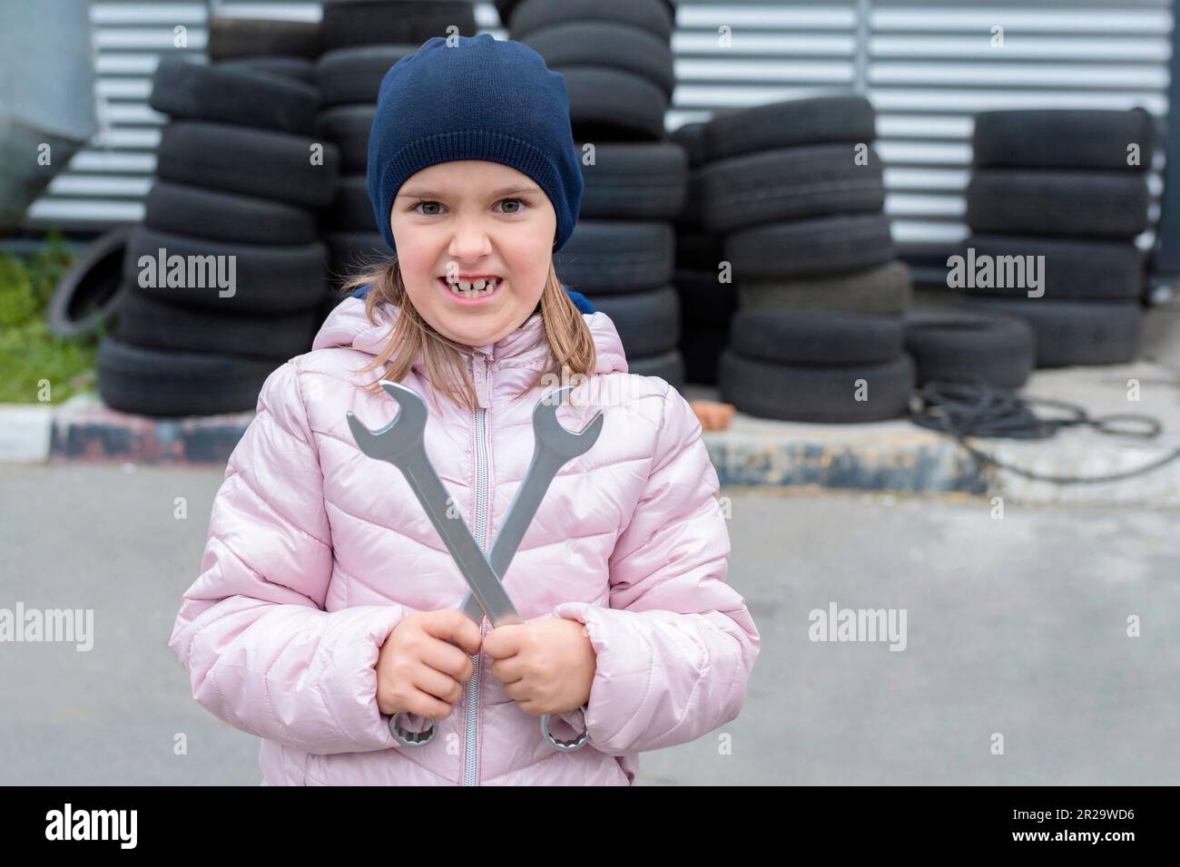 Ritratto di una bambina con chiave in mano, sullo sfondo delle gomme Foto Stock