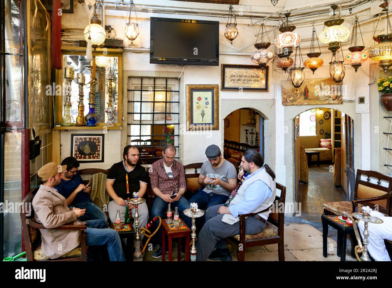 Istanbul Turchia. Uomini che fumano attraverso un hookah in un caffè Foto Stock