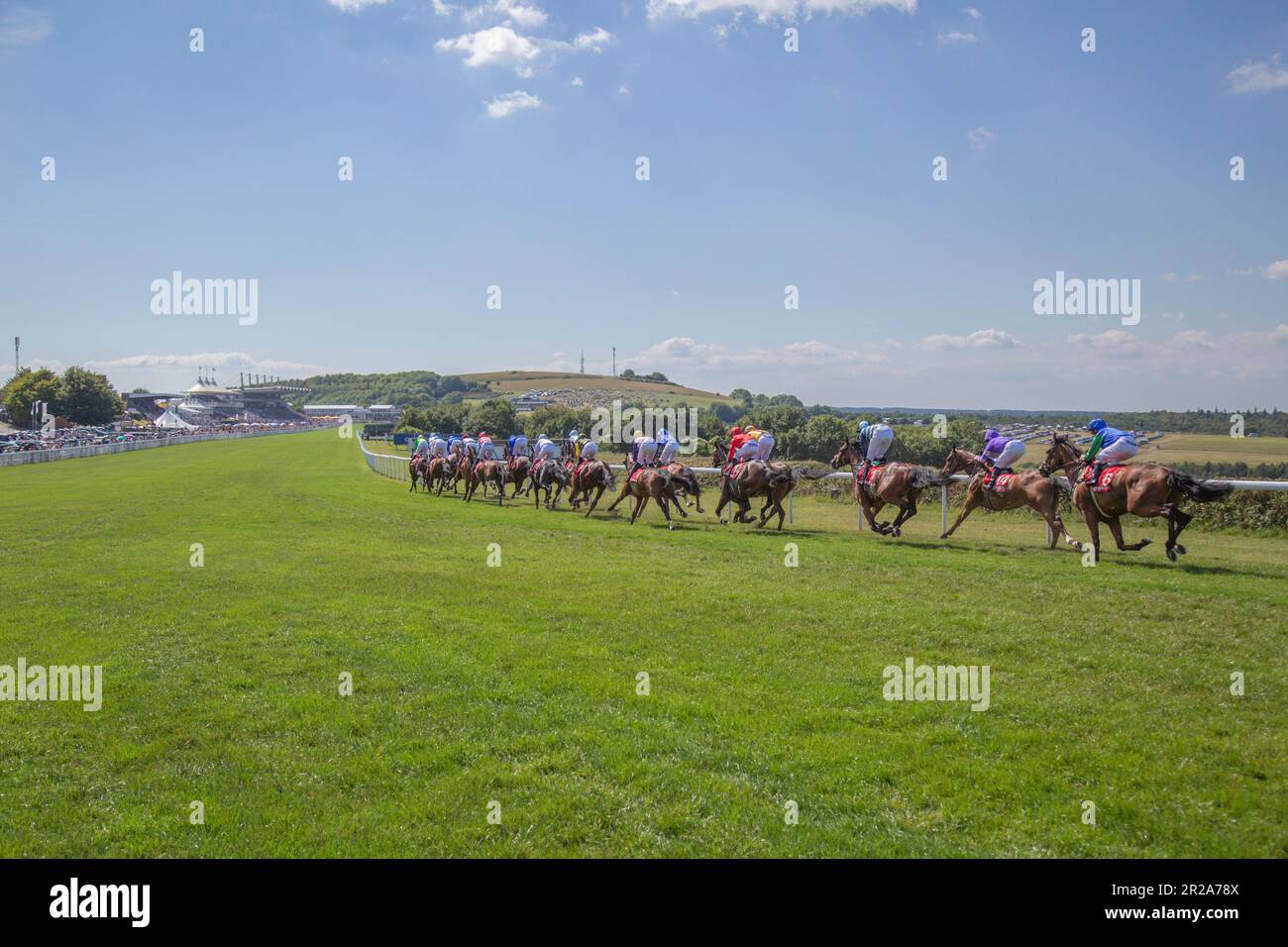 Cavalli e fantini si avvicinano alla linea di arrivo e oltrepassano le tribune di Goodwood nel Sussex occidentale Foto Stock