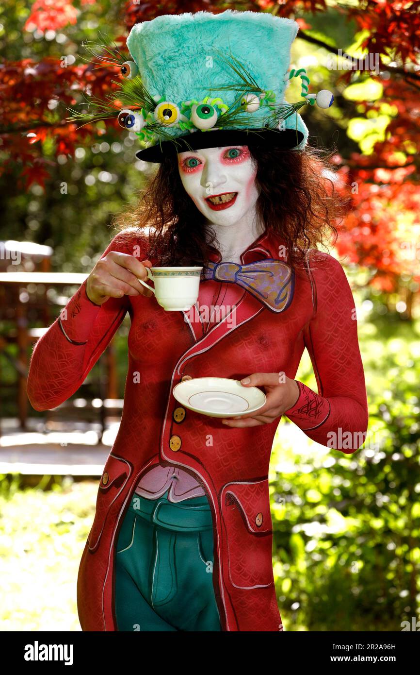 GEEK ART - Bodypainting e trasformazione: Alice nel paese delle meraviglie fotografa con Julia come il Mad Hatter nel giardino Czarnecki. Hamelin il 18 maggio 2023 - Progetto del fotografo Tschiponnique Skupin e del bodypainter Enrico Lein Foto Stock