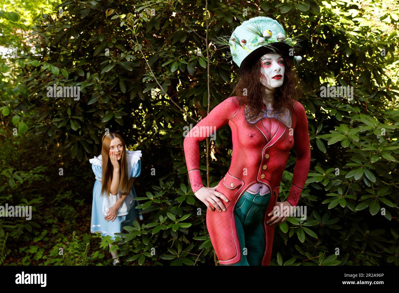 GEEK ART - Bodypainting e Transformaking: Alice nel paese delle meraviglie fotografa con Melina come Alice e Julia come la Mad Hatter nel giardino Czarnecki. Hamelin il 18 maggio 2023 - Un progetto del fotografo Tschiponnique Skupin e del bodypainter e trasformatore Enrico Lein Foto Stock