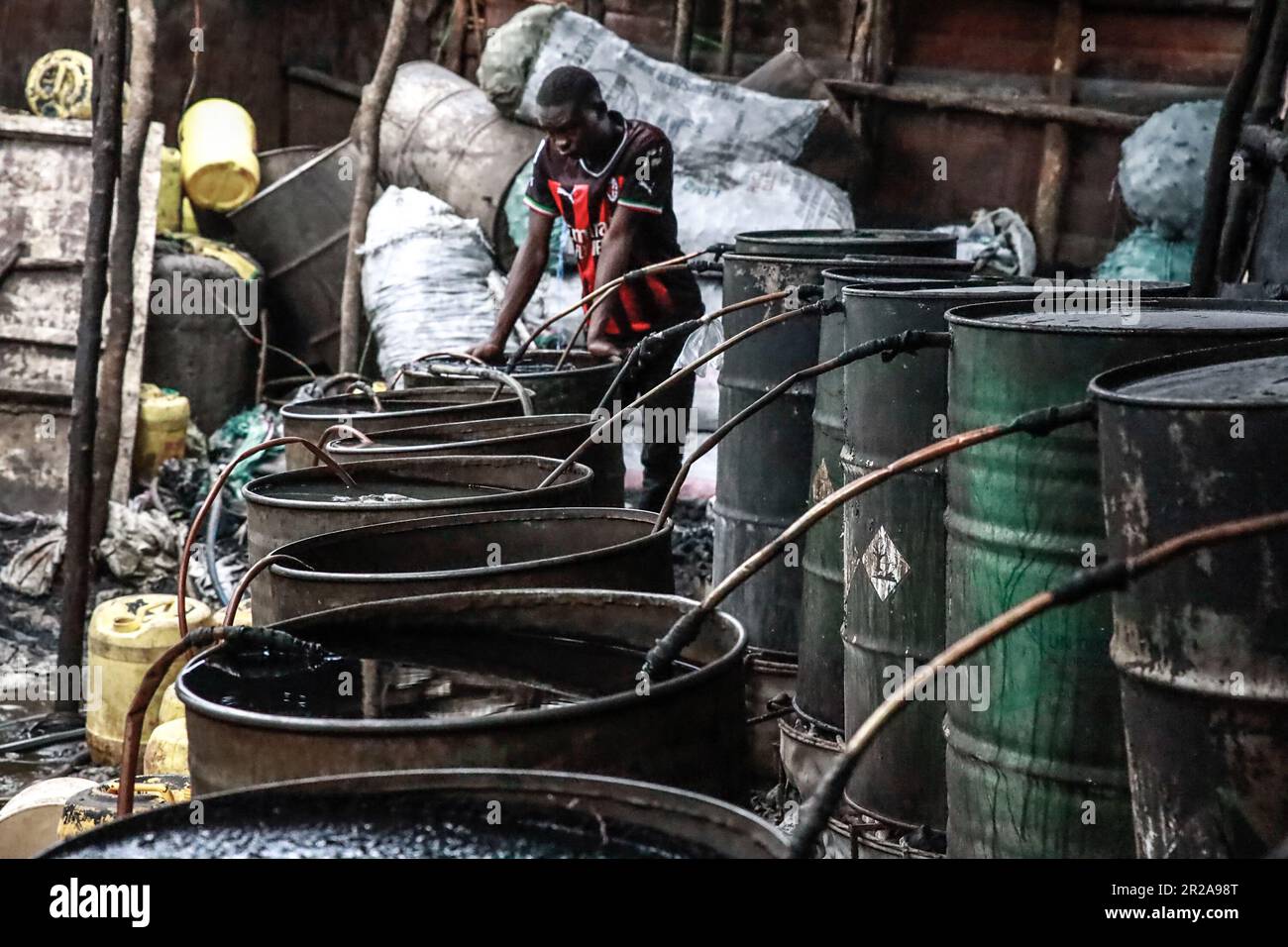 Un lavoratore si pone in un negozio di birra a Kibera Slum. I residenti di Nairobi camminano per le strade alla ricerca di pascoli più verdi nel mezzo dell'alto costo della vita e delle turbolenze economiche. Foto Stock