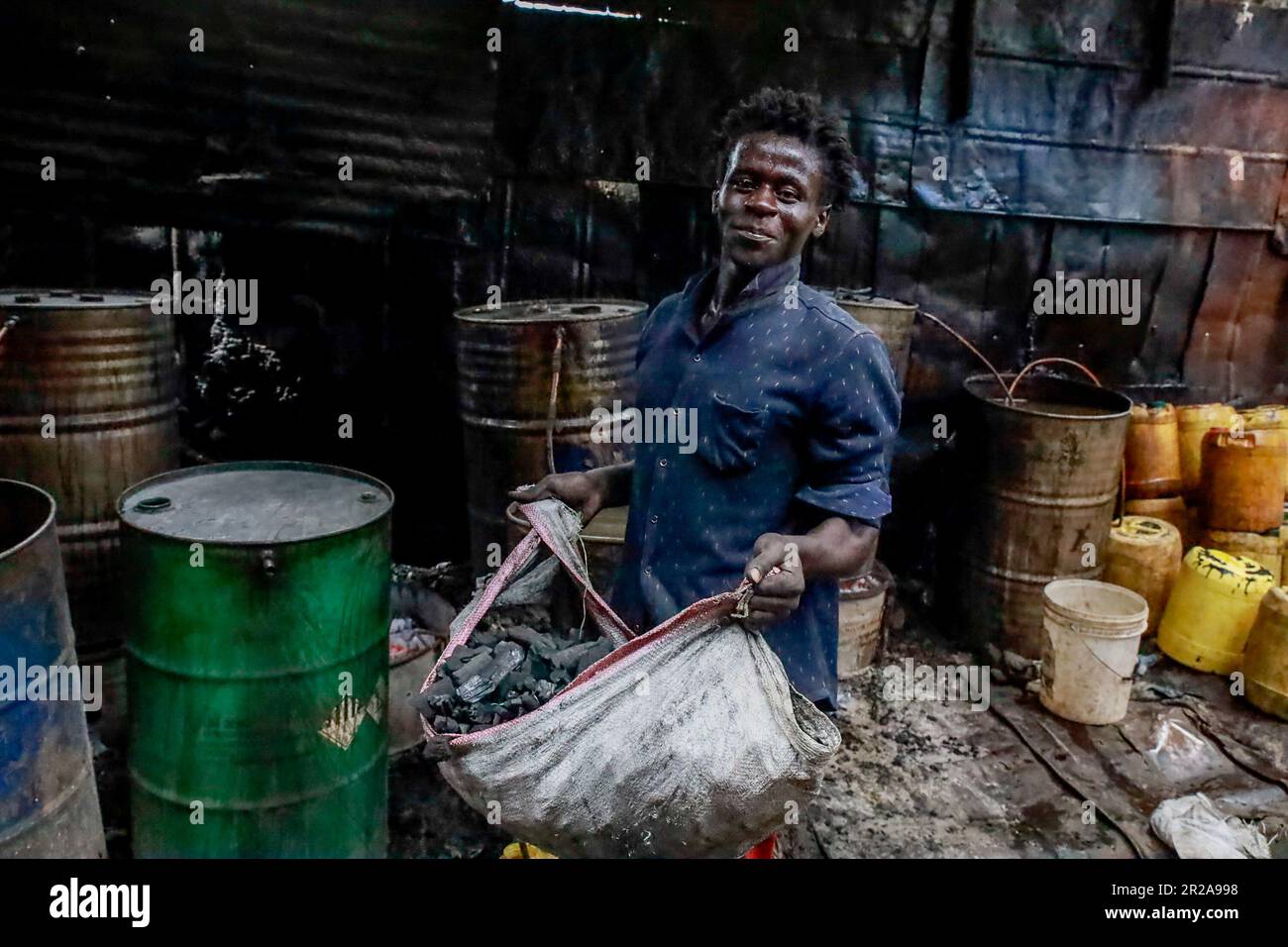 Un lavoratore si pone in un negozio di birra a Kibera Slum. I residenti di Nairobi camminano per le strade alla ricerca di pascoli più verdi nel mezzo dell'alto costo della vita e delle turbolenze economiche. Foto Stock