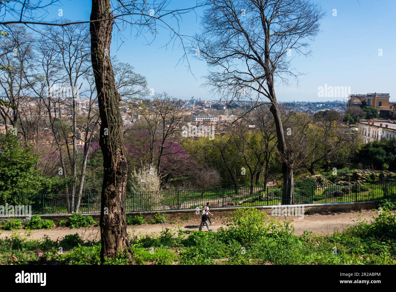 ROM, Italien, März 2023 Wanderweg auf dem Gianicolo Hügel mit einem Grandiosen Blick auf das historische Rom, zwei Spaziergänger genießen den Ausblick Foto Stock
