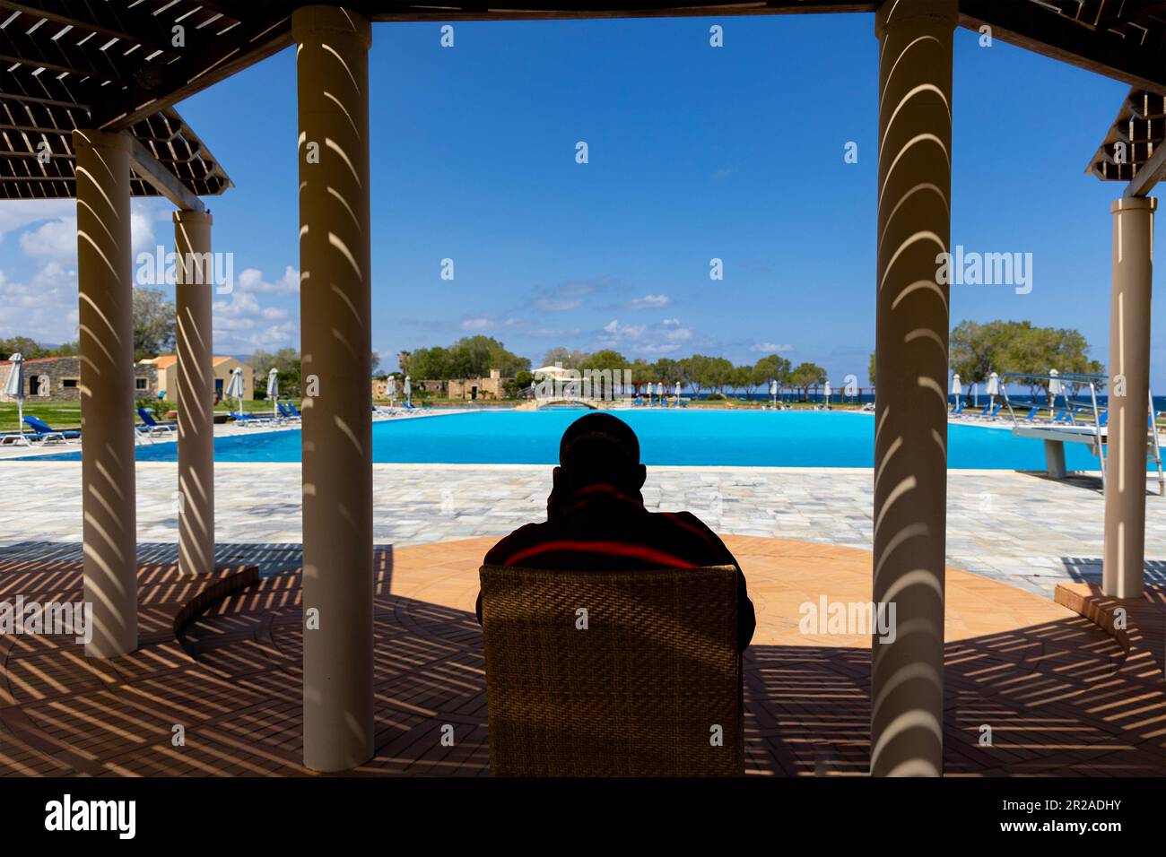 Silhouette di guardia della vita seduta vicino alla piscina, Kalimera Kriti Resort, Sisi, Lasithi, Creta, Grecia, Europa. Foto Stock
