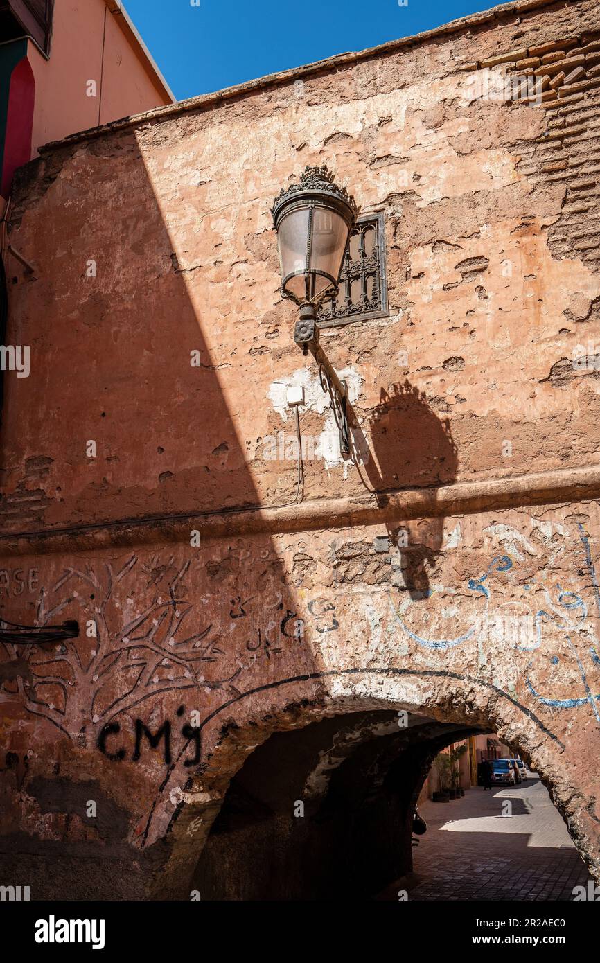 Antico arco in pietra con lampada nel quartiere Kasbah di Marrakech, Marocco Foto Stock
