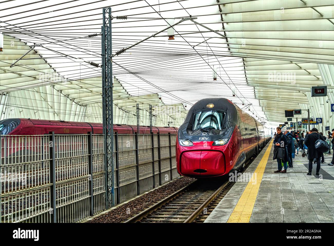 Treno ad alta velocità che arriva al binario della stazione Mediopadana di Reggio Emilia. Viaggiatori in attesa di salire a bordo del treno. Emilia Romagna Foto Stock