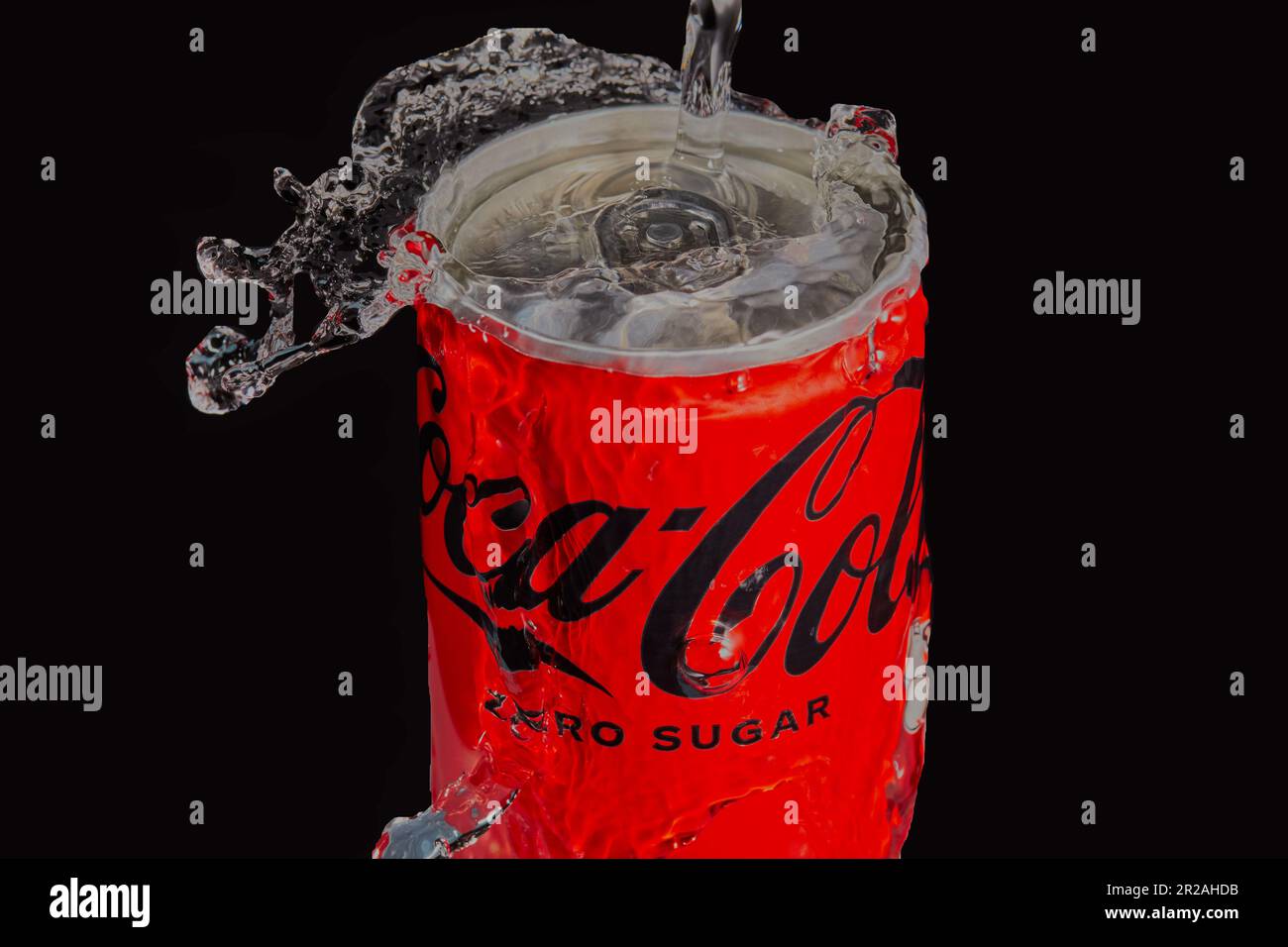 Lattina di Coca-Cola con acqua che viene spruzzata su di esso con uno sfondo scuro. Immagine del prodotto in studio Mansfield,Nottingham,Regno Unito. Foto Stock