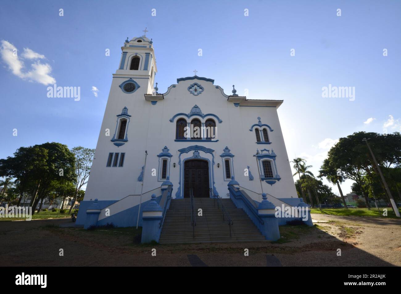 Facciata della Chiesa cattolica in Brasile con scala con cielo blu con nuvole e la natura sul lato. foto grandangolare Foto Stock