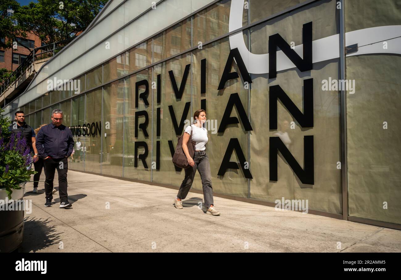 La gente passa davanti alla futura casa di uno showroom Rivian, il quartiere Meatpacking a New York, mercoledì 17 maggio 2023. Una volta aperta, Rivoan si unirà ad altri produttori di veicoli elettrici di lusso Tesla, Genesis e Lucid nel quartiere Meatpacking. (© Richard B. Levine) Foto Stock