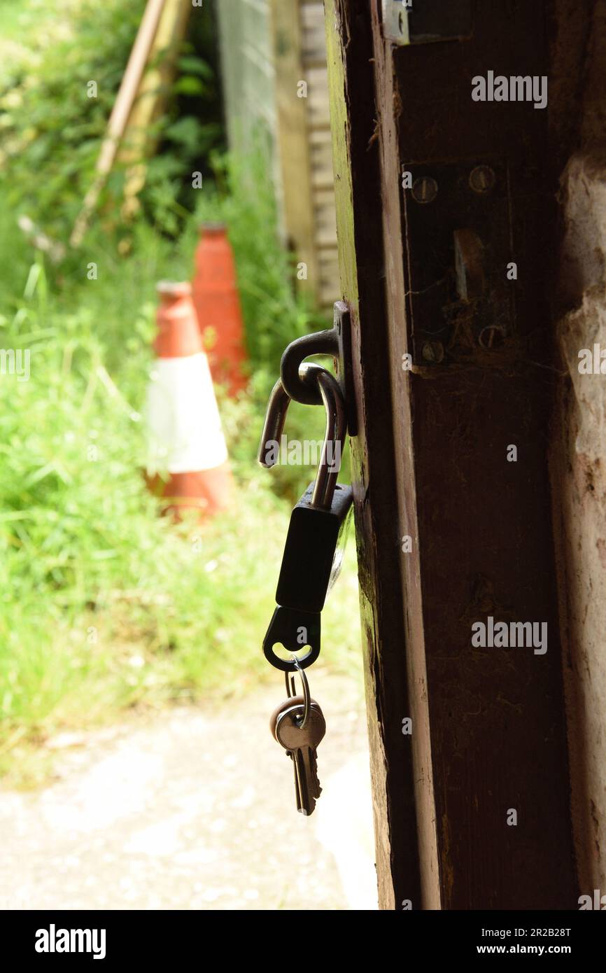 Lucchetto e chiave appesi alla porta dell'azienda agricola Foto Stock