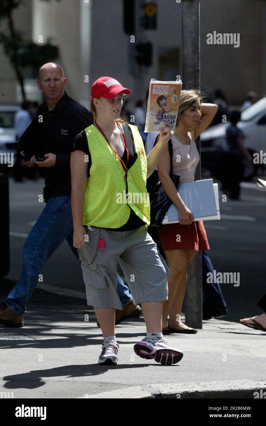 Un venditore di strada che vende The Big Issue, una rivista quindicinale che presenta gli affari attuali, l'intrattenimento, la fotografia e il commento, venduto per le strade di città e città in tutta l'Australia da persone che vivono senza casa o disoccupazione di lunga durata. Aiuta le persone ad aiutare se stesse, poiché i fornitori mantengono la metà del prezzo di copertura di $5 dollari di ogni rivista che vendono. Posizione: All'angolo tra Elizabeth e King Street, Sydney. Foto Stock