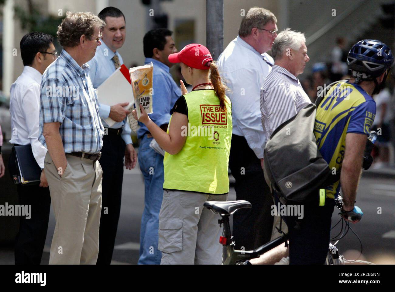 Un venditore di strada che vende The Big Issue, una rivista quindicinale che presenta gli affari attuali, l'intrattenimento, la fotografia e il commento, venduto per le strade di città e città in tutta l'Australia da persone che vivono senza casa o disoccupazione di lunga durata. Aiuta le persone ad aiutare se stesse, poiché i fornitori mantengono la metà del prezzo di copertura di $5 dollari di ogni rivista che vendono. Posizione: All'angolo tra Elizabeth e King Street, Sydney. Foto Stock