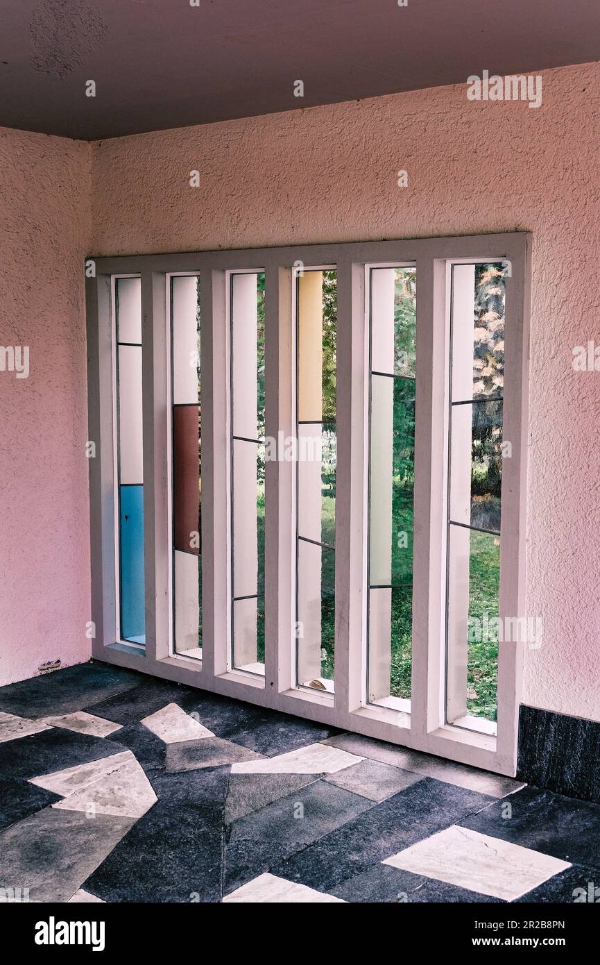 Una finestra di vetro colorato mostra un capolavoro di colori vibranti e design intricati. La luce solare filtra attraverso il vetro traslucido. Foto Stock