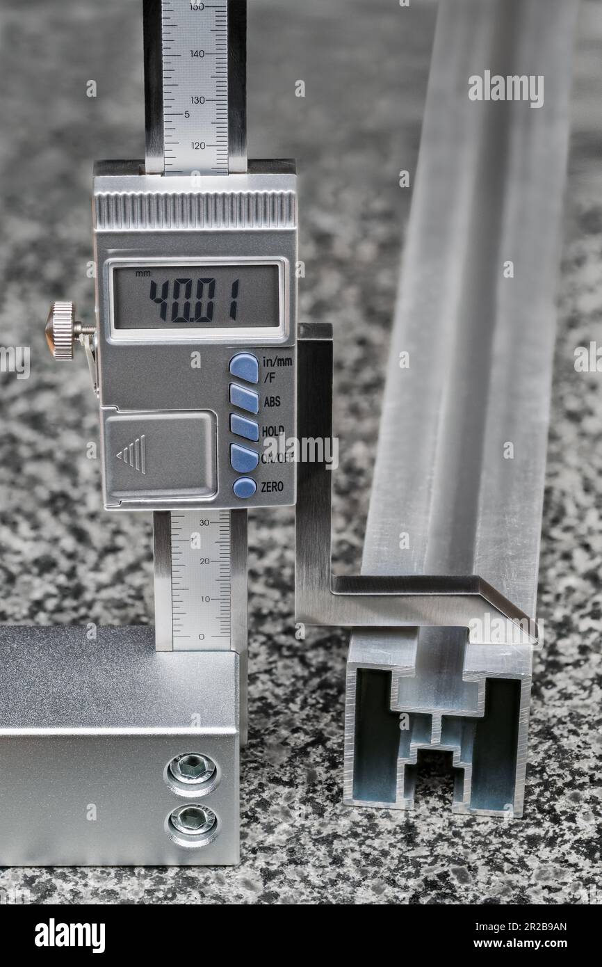 Misuratore di altezza digitale preciso con punta in metallo su piastra piana in granito. Misura della dimensione del profilo di alluminio. Processo di marcatura. Foto Stock