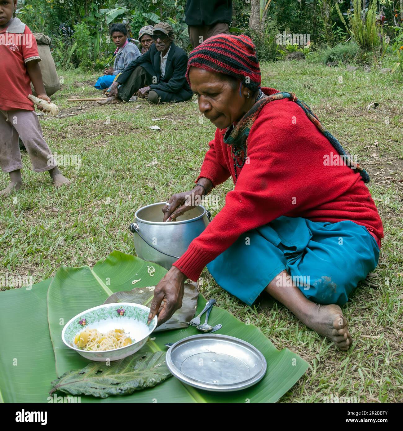 PNG, Papua Nuova Guinea; Highlands orientali; Goroka; Una donna Papua prepara un pasto semplice. Eine Papua-Frau bereitet eine einfache Mahlzeit zu. Foto Stock