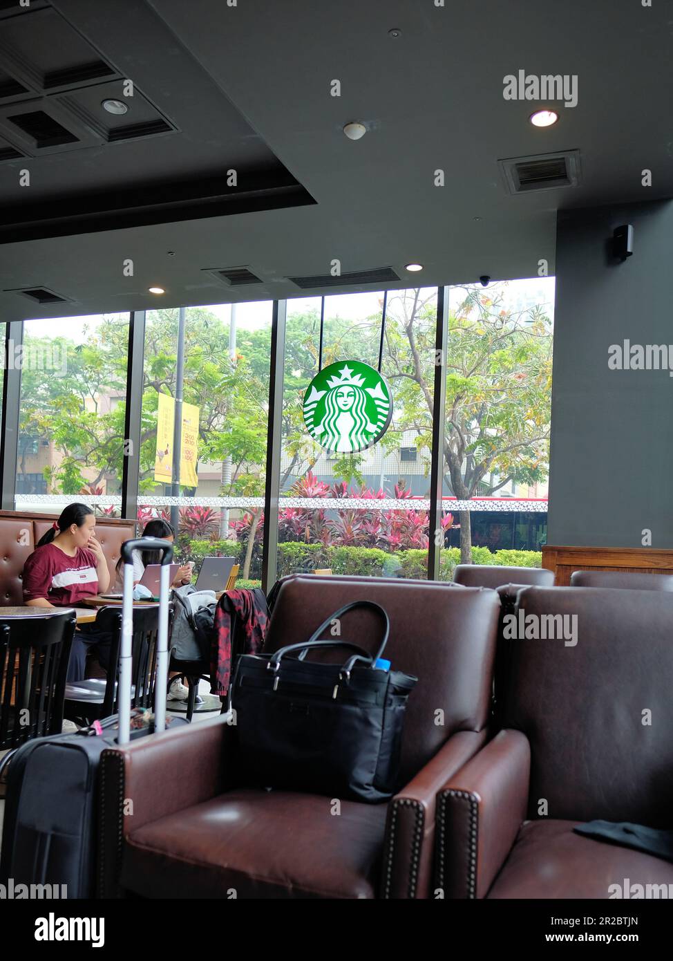 Vista interna Starbucks Coffee Shop, sede a Kaohsiung, Taiwan; studenti che studiano; interessi commerciali americani e investimenti all'estero e in Asia. Foto Stock