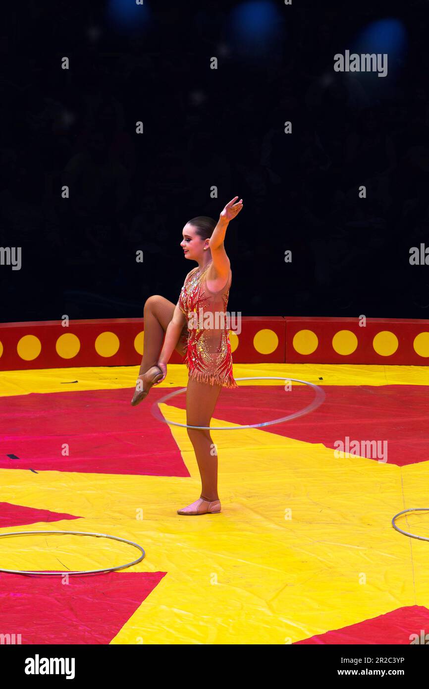 Suonatore di circo femminile, giocoleria e balli con cerchi di hula. Foto Stock