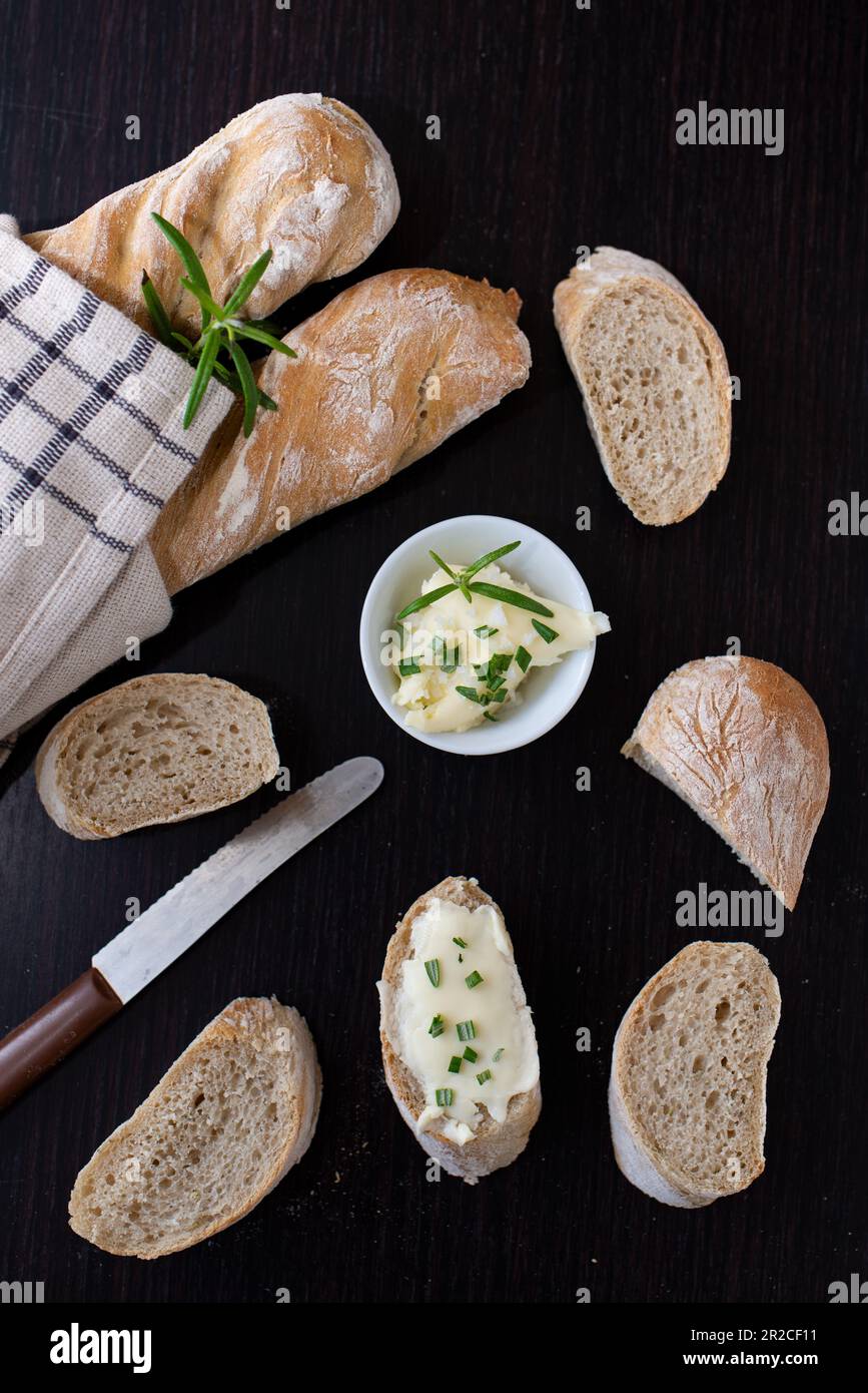 Pane fresco francese fatto in casa baguette con aglio selvatico su sfondo scuro Foto Stock